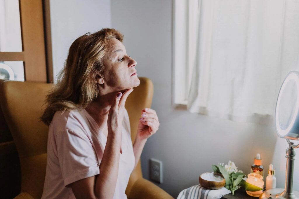 woman moisturizing for self care over fifty