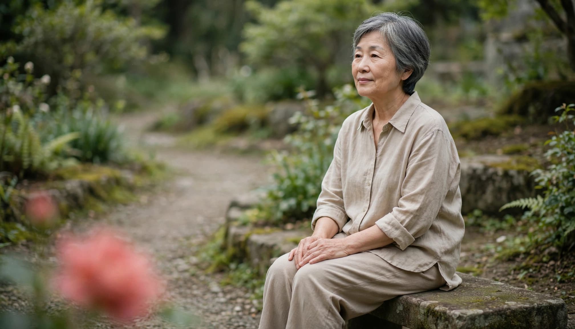 Older woman sitting in a garden for a grounding pause before a social event.